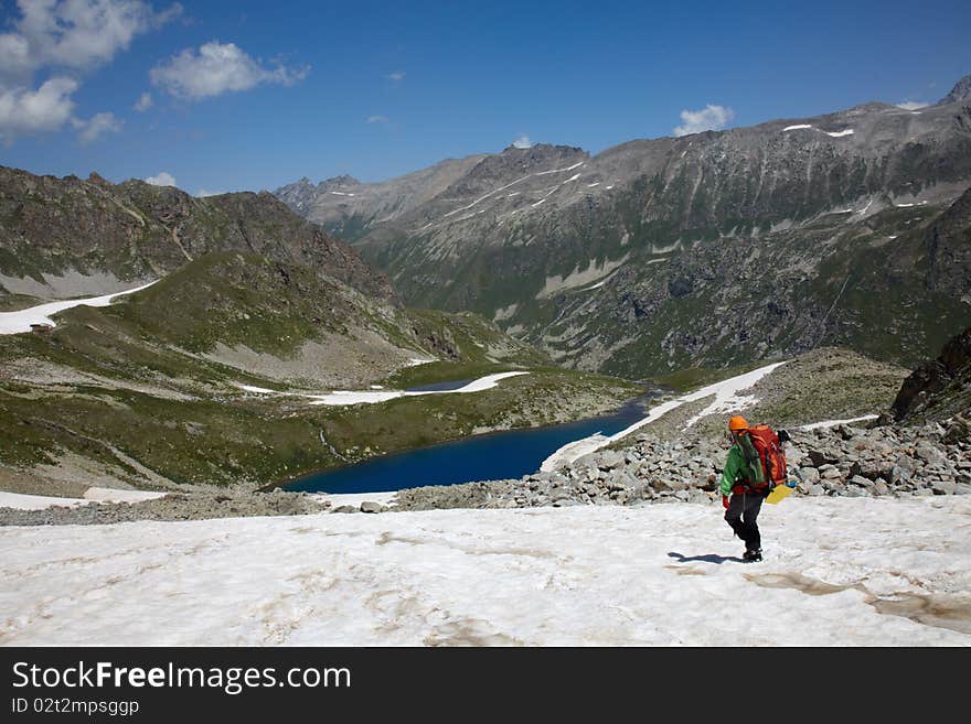 Backpacker Walking Down On A Snow