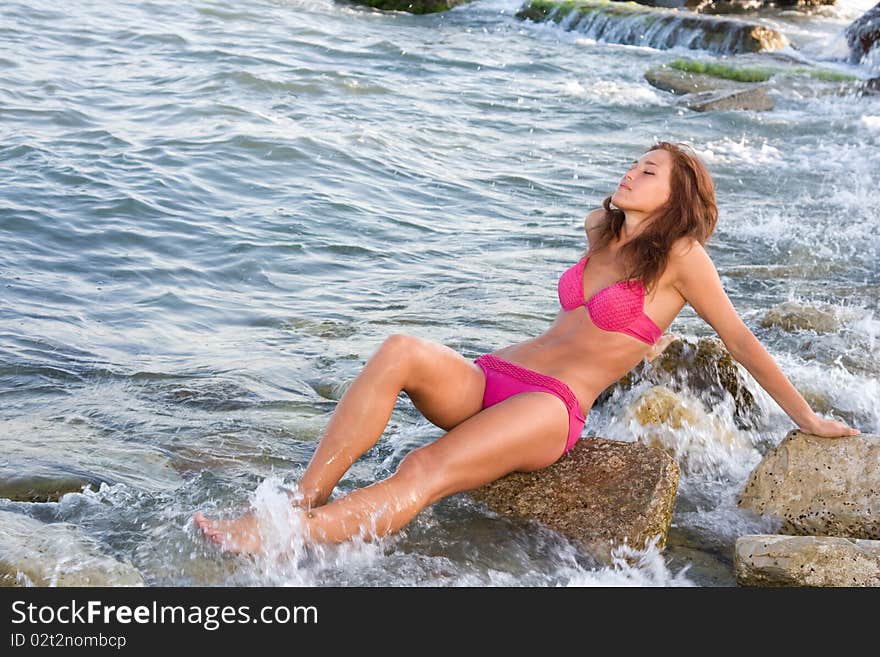 A Young Girl On A Rock In The Sea