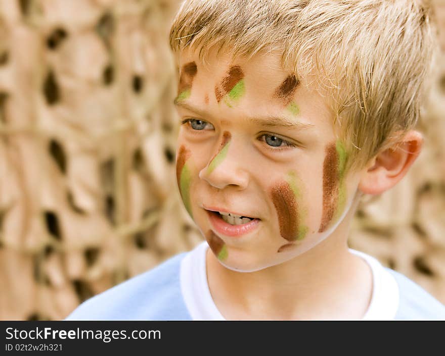 A young boy with camouflage paint on his face