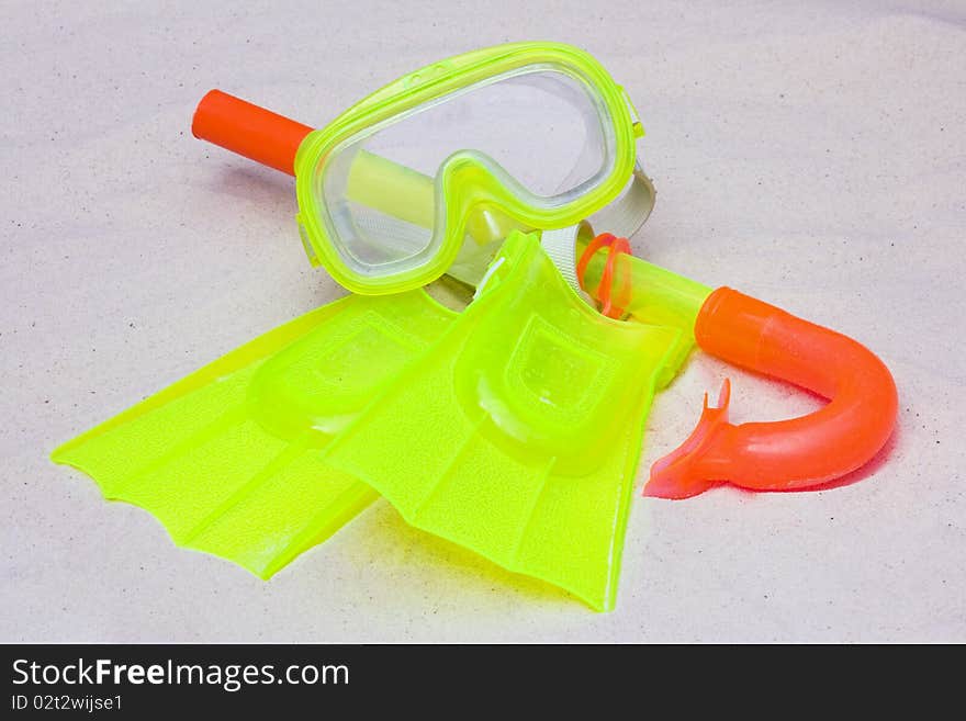 A child's snorkel, mask and flippers laying on the sand. A child's snorkel, mask and flippers laying on the sand