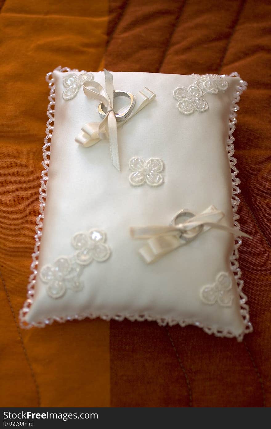 Wedding rings lying on a white pillow