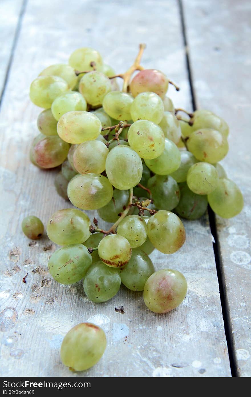 Green grapes on a wooden table