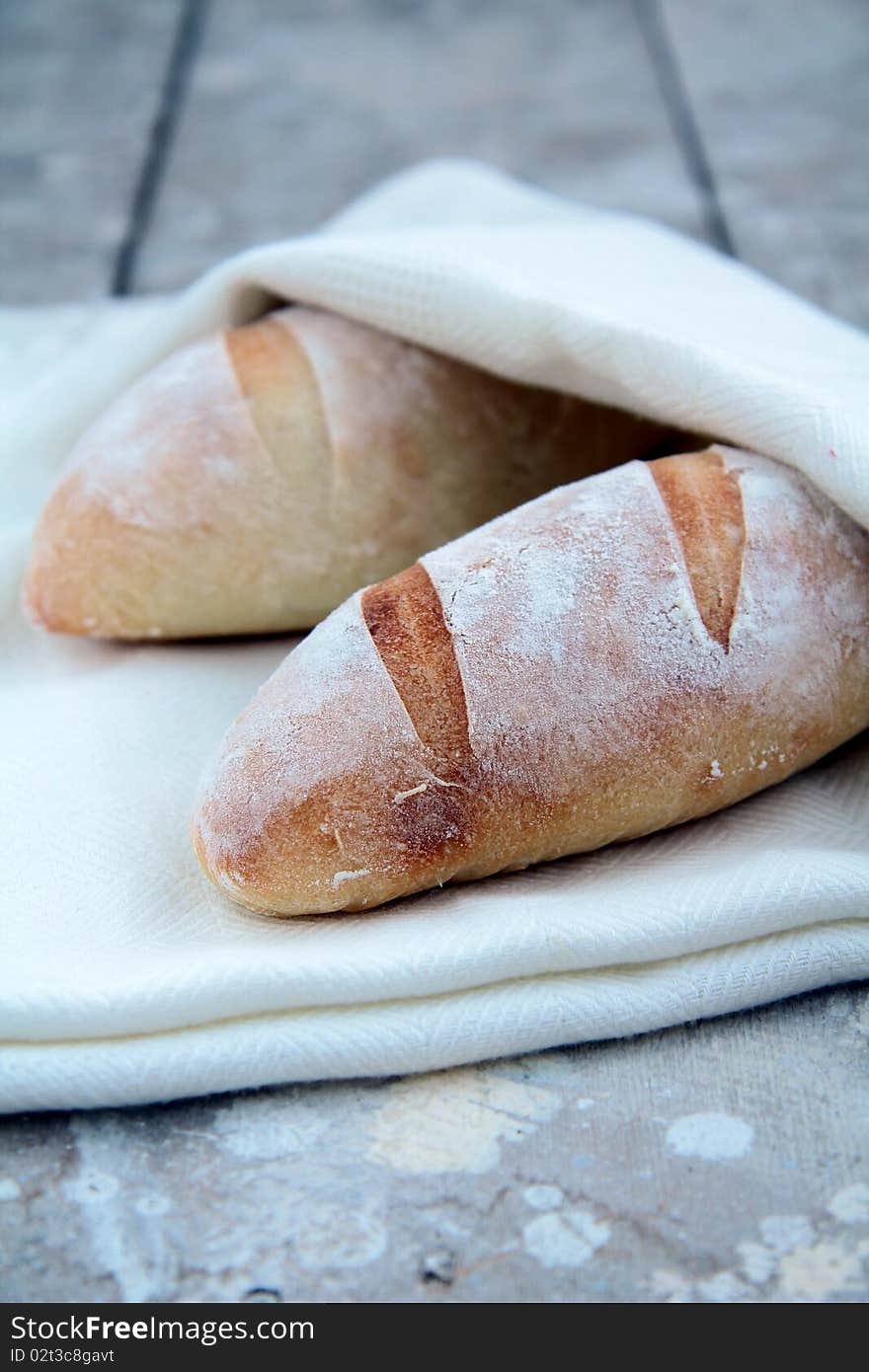 Two Baguette and cloth on a wooden table. Two Baguette and cloth on a wooden table