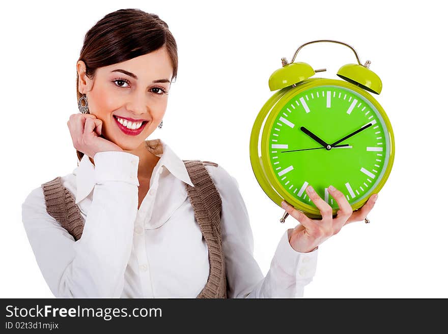 Portrait of lady holding alarm clock with one hand and one hand on chin against white background