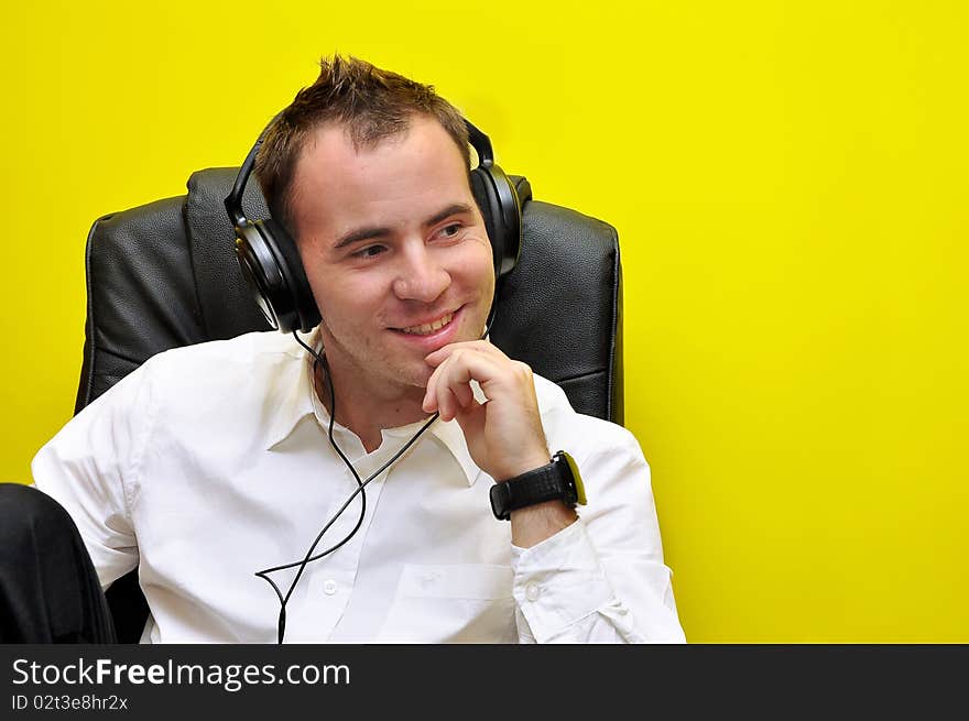 Young Business Man enjoying good, quality music to his headphones 01. Young Business Man enjoying good, quality music to his headphones 01