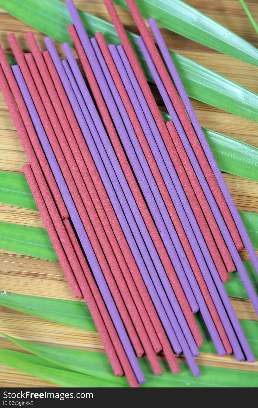 Herbal fragrance sticks background with green leaves.