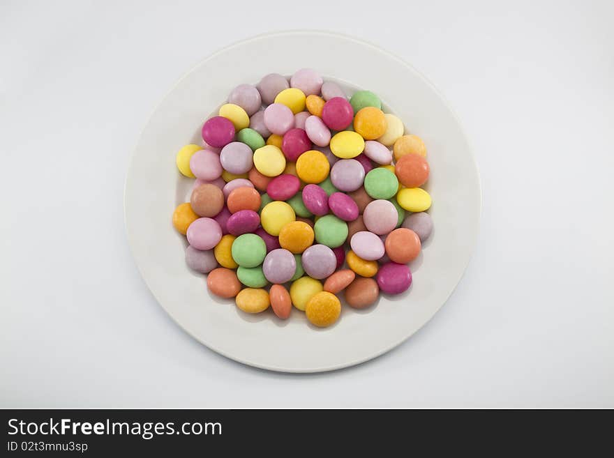 Multi color candy on white dish