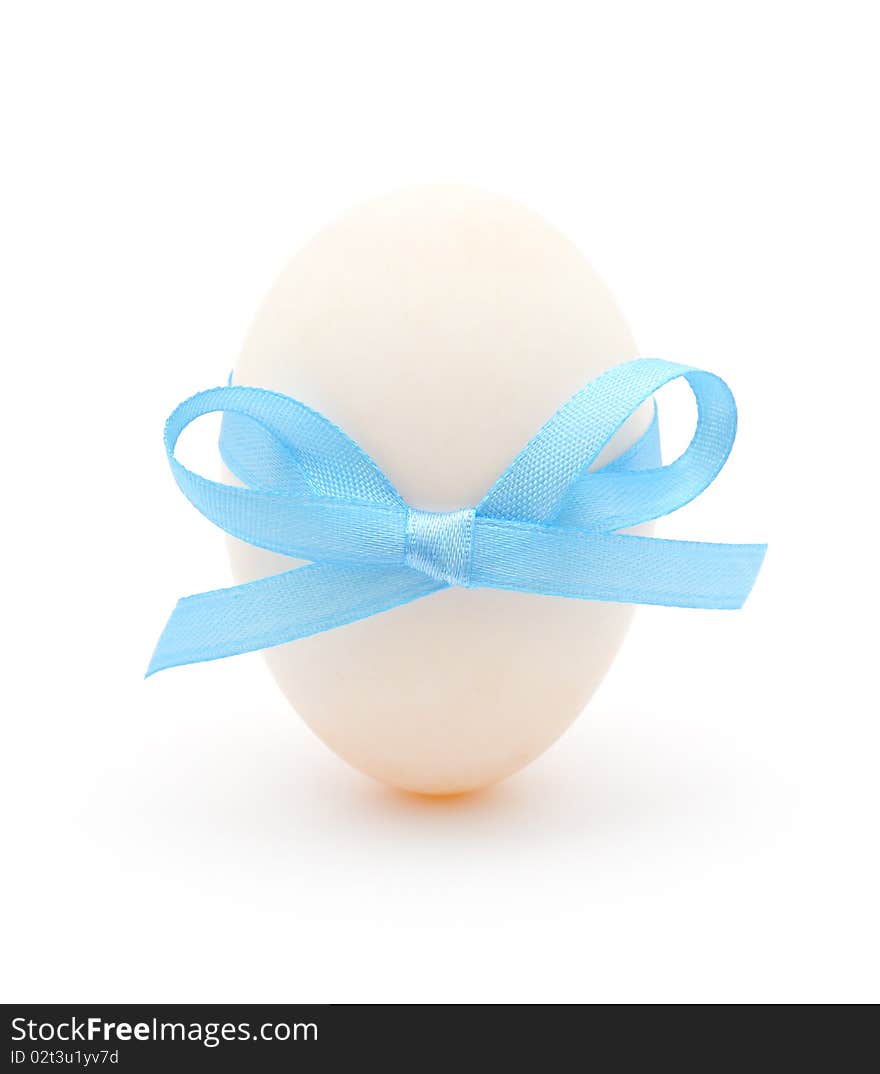 White egg wrapped around with blue ribbon over white background. White egg wrapped around with blue ribbon over white background