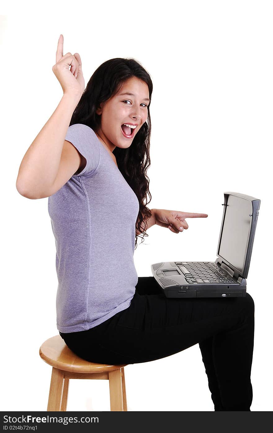 An happy young woman pointing with her finger to her laptop and up in
the air, sitting in black jeans on a chair, for white background. An happy young woman pointing with her finger to her laptop and up in
the air, sitting in black jeans on a chair, for white background.