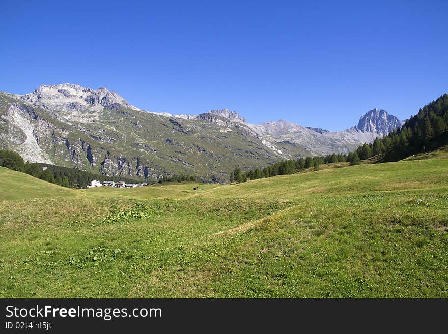 Swiss landscape with green meadows and high peaks