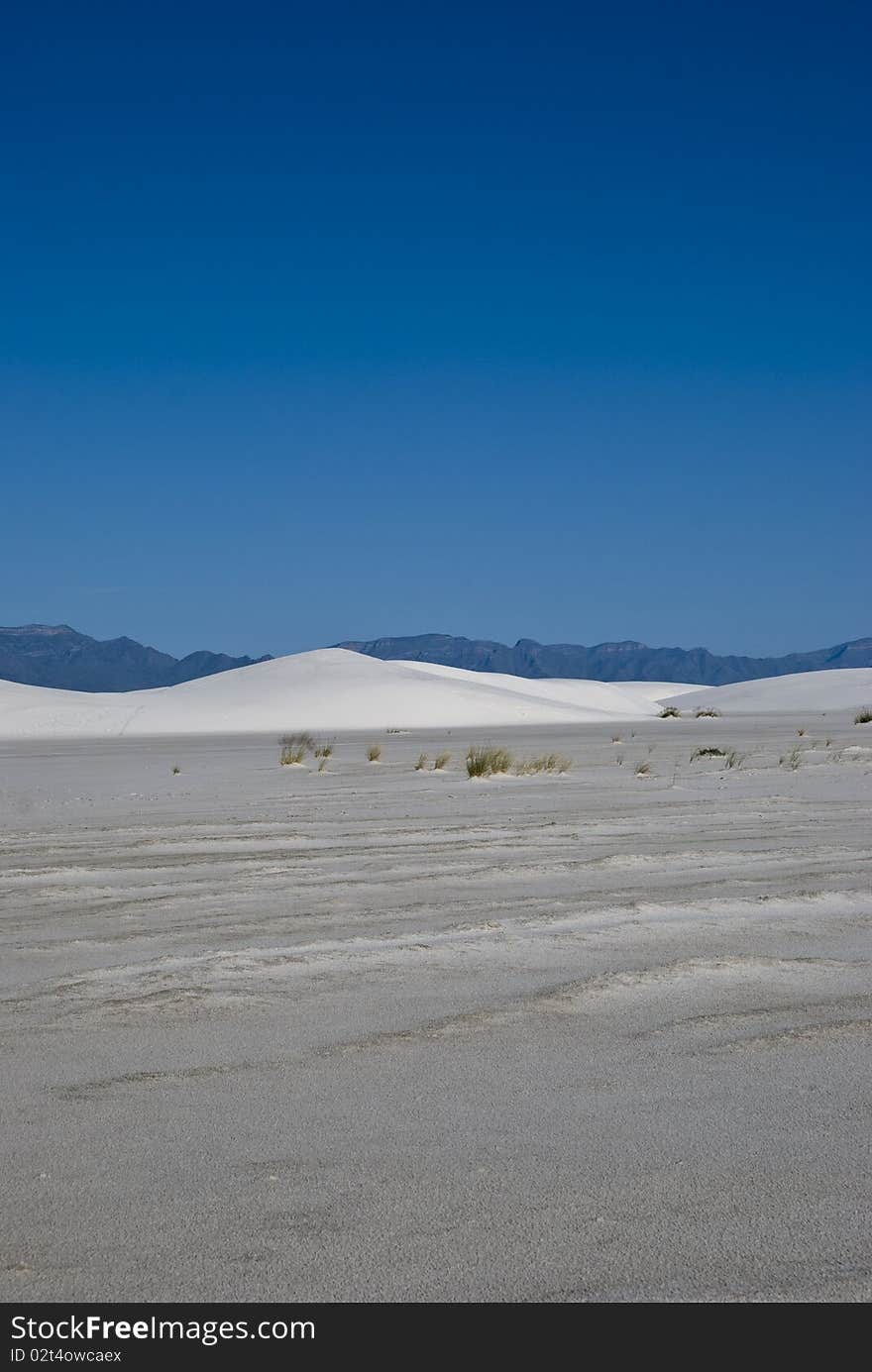 A lone white sand dune in a vast desert. A lone white sand dune in a vast desert