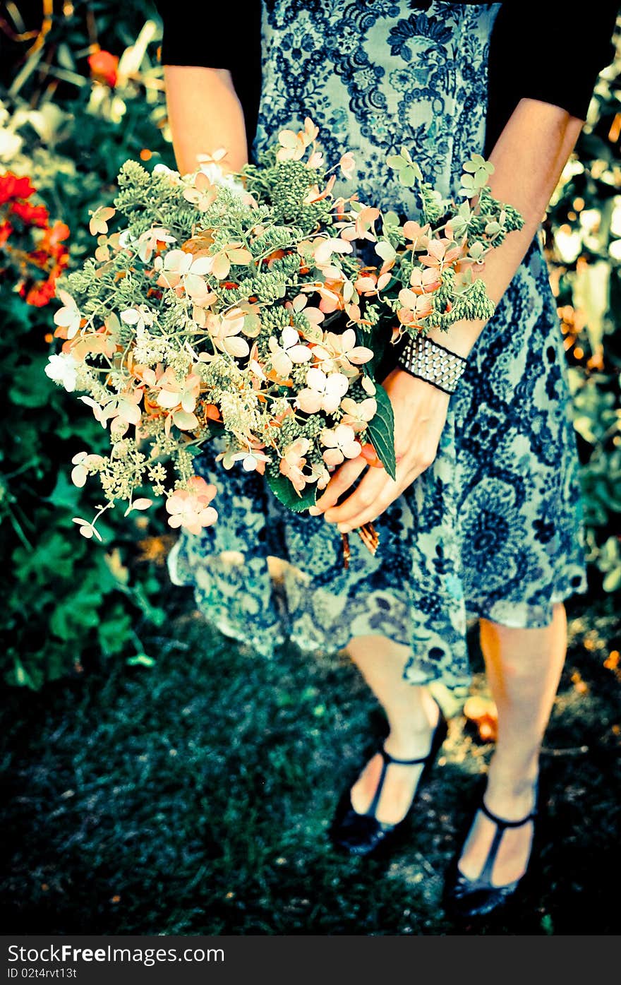 Girl in summer dress holding homemade flower bouquet; trendy colors; angle two. Girl in summer dress holding homemade flower bouquet; trendy colors; angle two