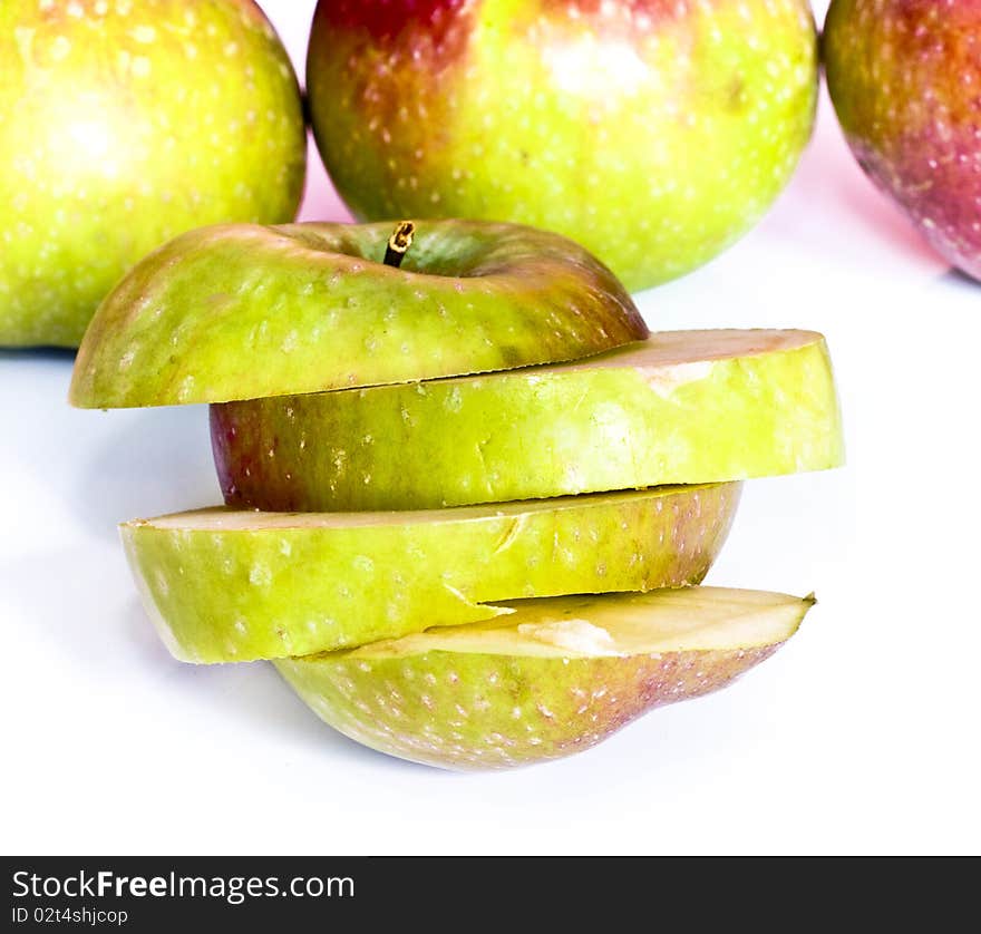 Fresh apple slices and apples in background, isolated on white