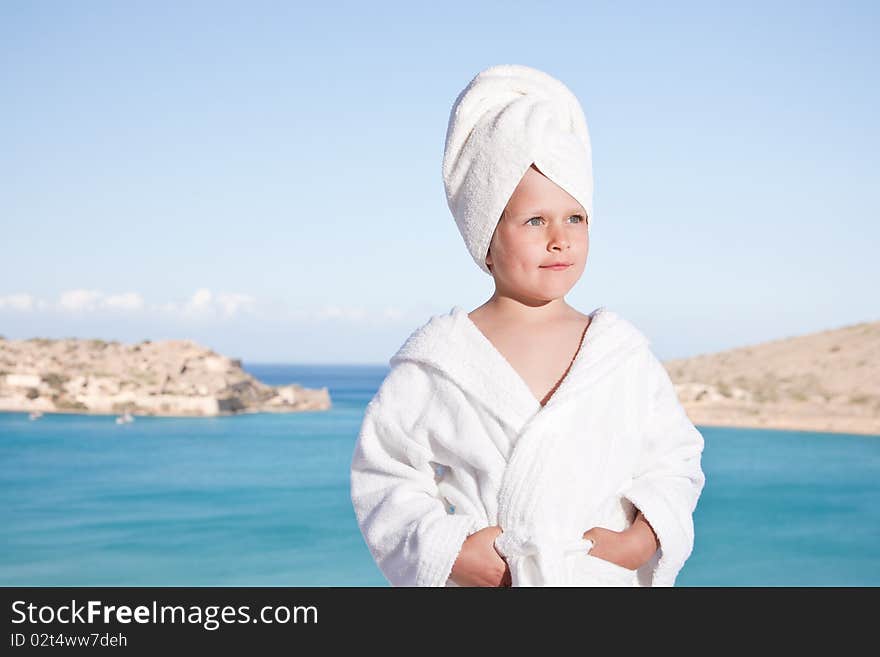 Little girl with towel on head in white bathrobe