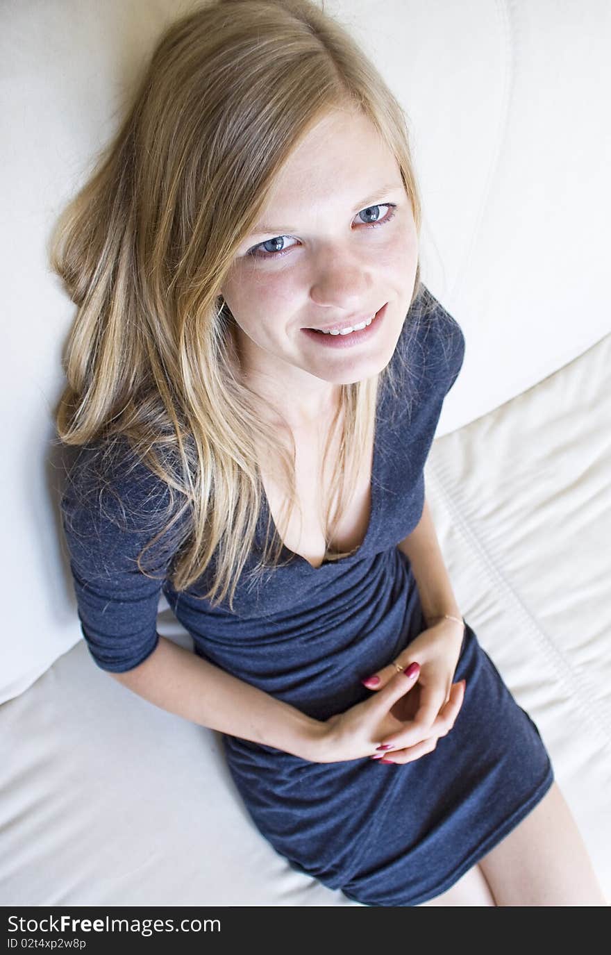 Top-to-bottom view of a cute girl sitting on the couch. Top-to-bottom view of a cute girl sitting on the couch