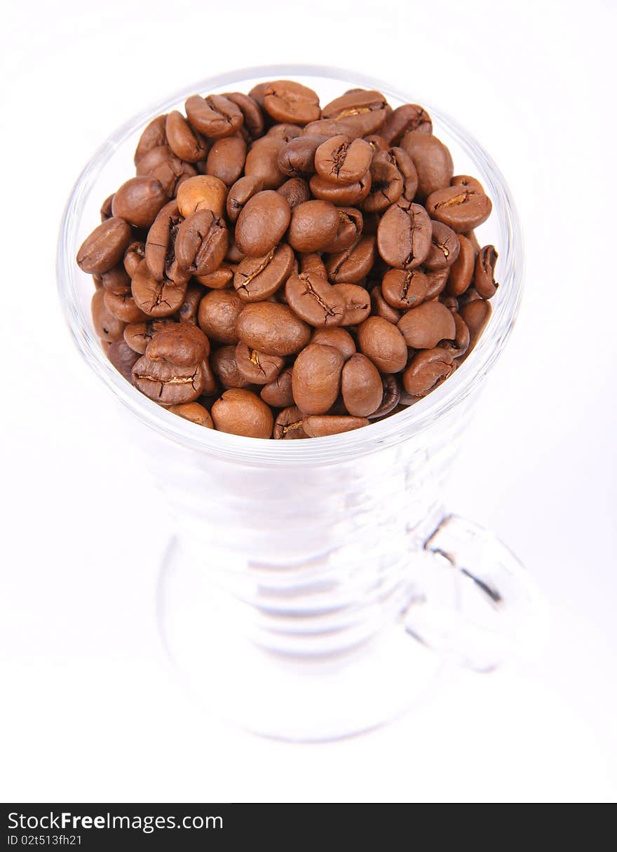 Glass of coffee beans on white background