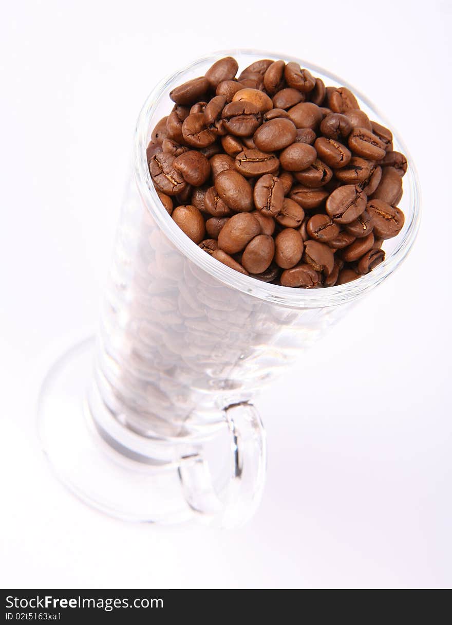 Glass of coffee beans on white background