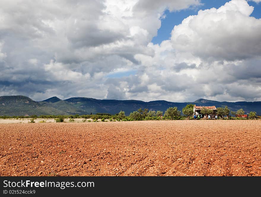 Rural landscape with field,mountain and little house