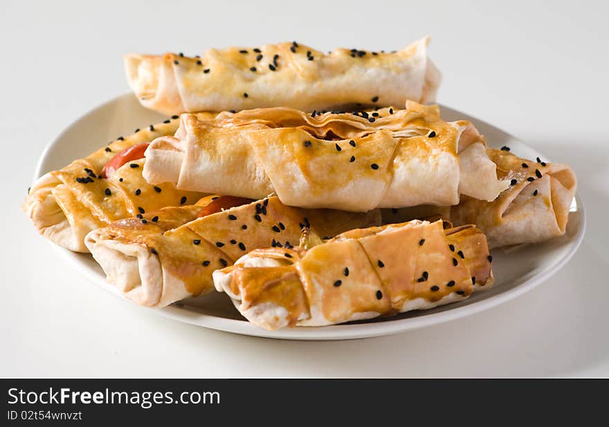 Scone with sesame seeds on a white plate.