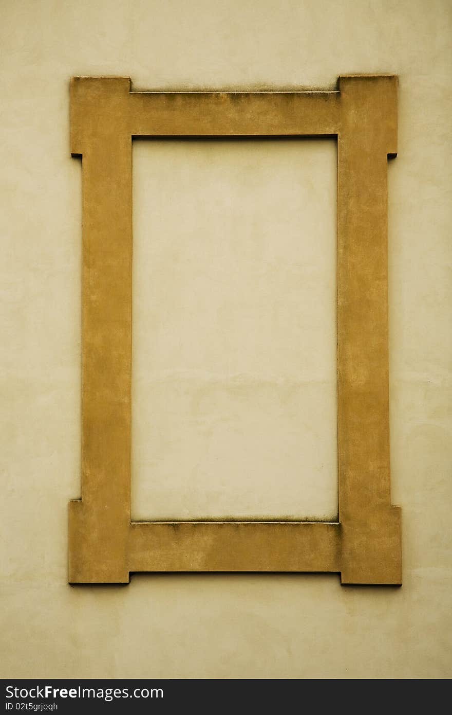 A rectangular frame made of stone in a deep yellow or gold color, on a yellow wall in Italy. Blank space for copy. A rectangular frame made of stone in a deep yellow or gold color, on a yellow wall in Italy. Blank space for copy.