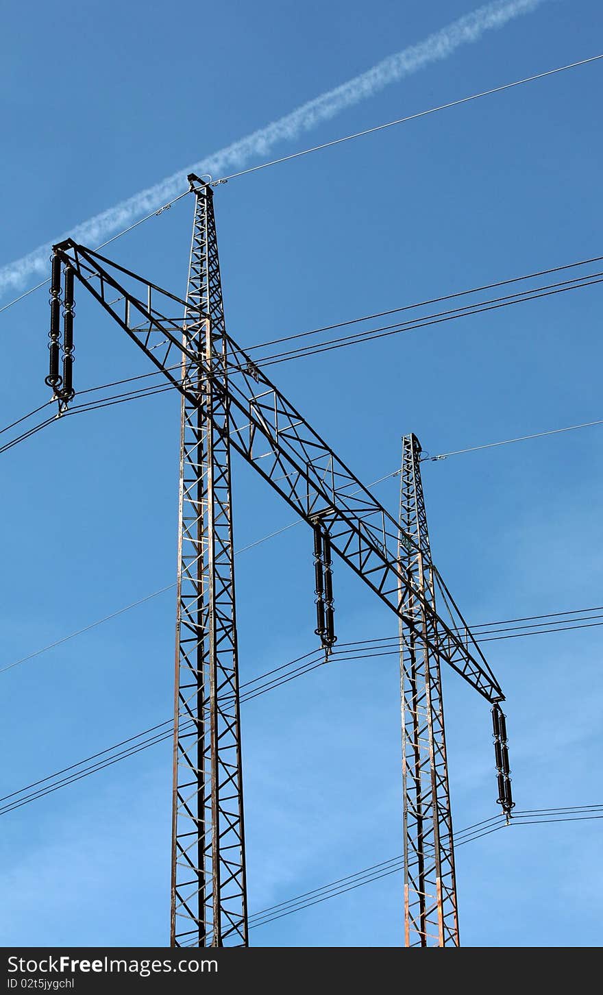 Electricity pylons and cables on the bright blue sky