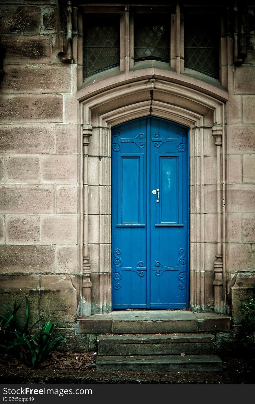 An entrance to an old building with a blue door. An entrance to an old building with a blue door.