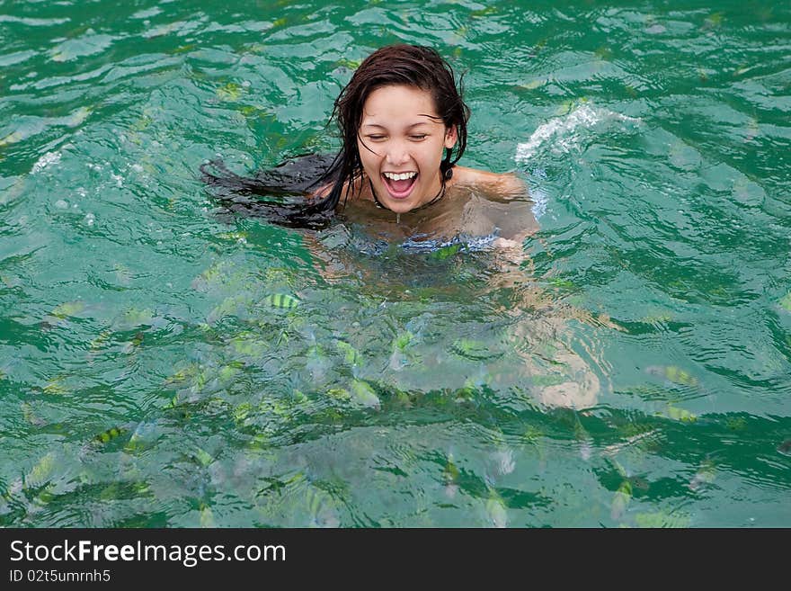 Girl swims with tropical fish, adventure in the sea