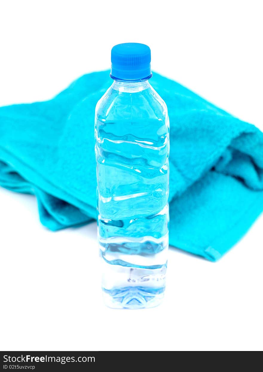 A bottle of water and a sports towel isolated against a white background. A bottle of water and a sports towel isolated against a white background