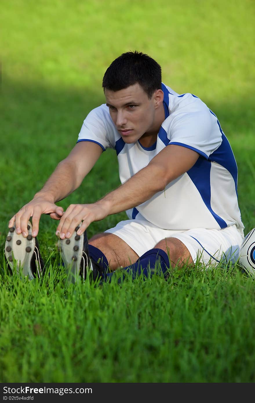 Young soccer player on green grass