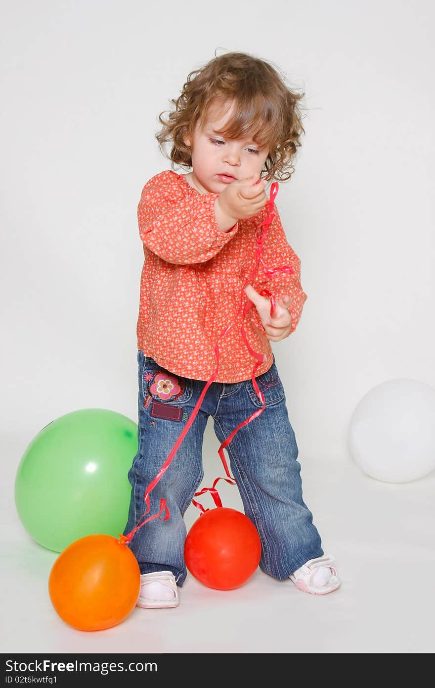 Cute little girl playing with colorful balloons