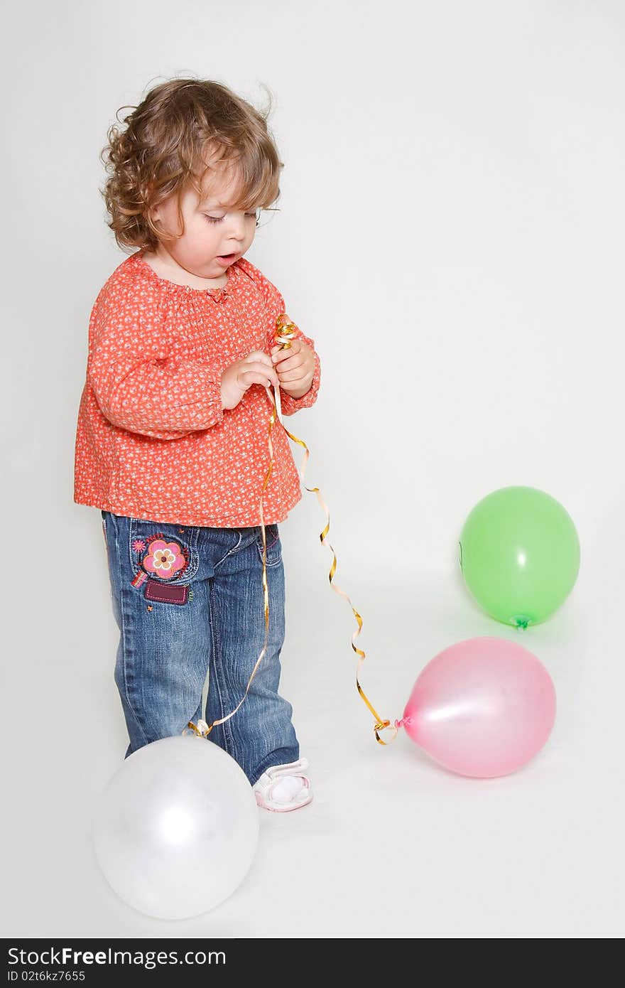 Little girl playing with colorful balloons