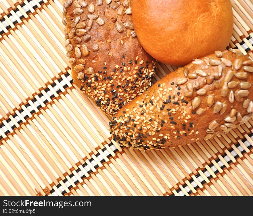 Fresh bread rolls on a straw background