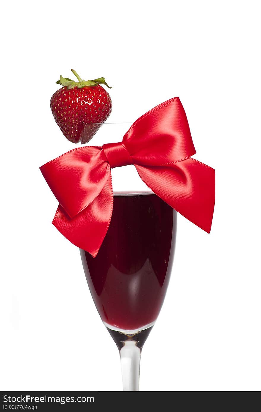 Strawberry and red bow as decoration on the glass of alcohol. Strawberry and red bow as decoration on the glass of alcohol