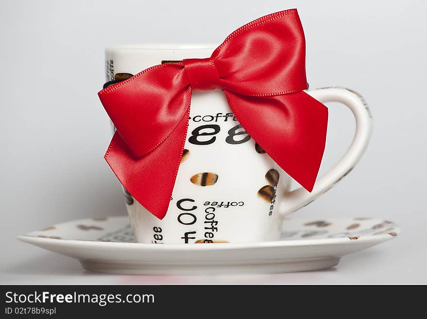 Designed cup of black coffee with red ribbon. Designed cup of black coffee with red ribbon