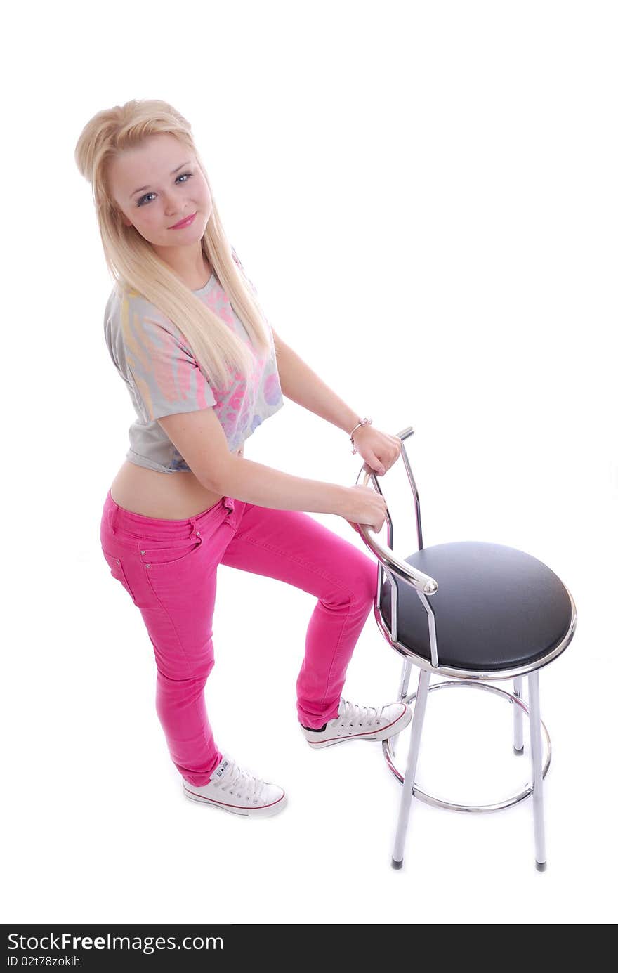 Photograph of pretty young blond girl isolated against white posing with stool. Photograph of pretty young blond girl isolated against white posing with stool