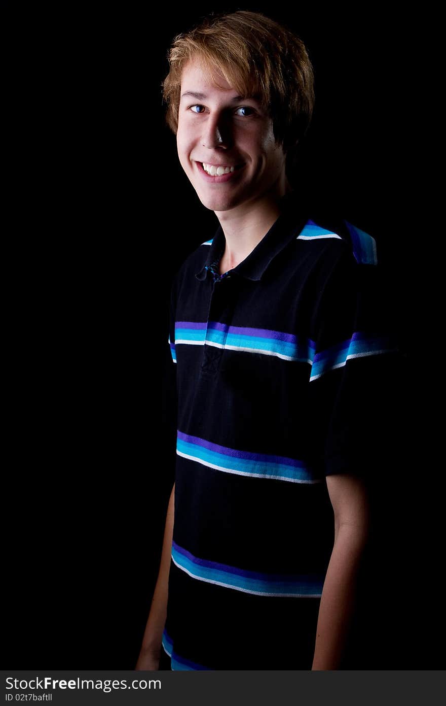 Young teenage boy with a big smile. Isolated over black background. Young teenage boy with a big smile. Isolated over black background.