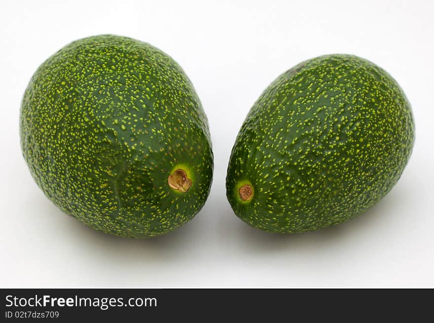 Two green avocado on white background almost ready to eat.