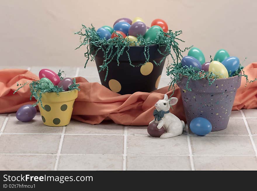 Three easter painted pots hold eggs and grass for the holiday