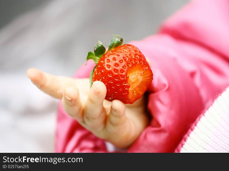 Strawberry in child hand