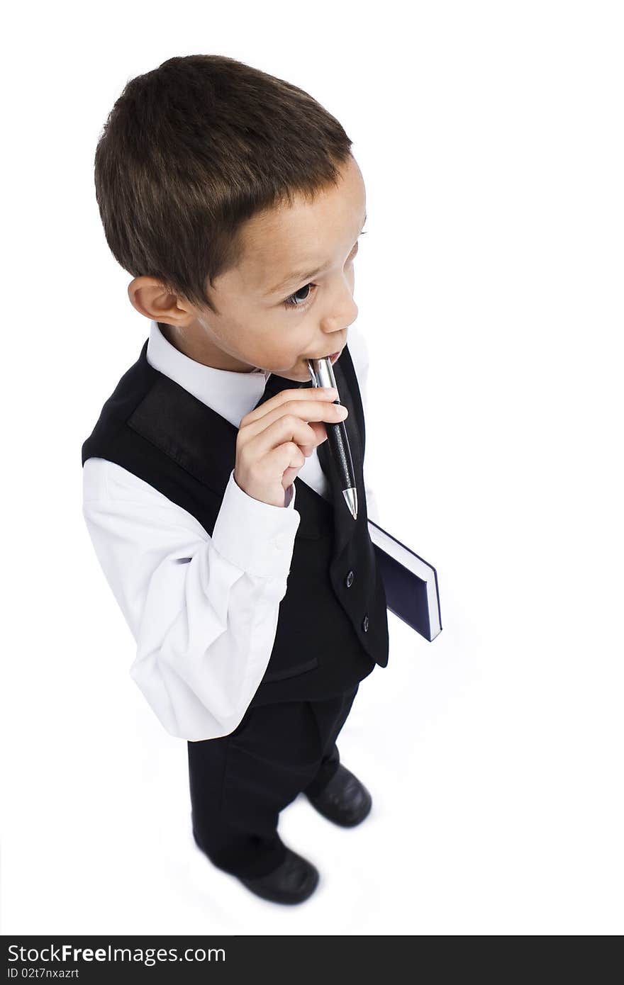 Boy holding pen in his mouth holding book in his hand. Boy holding pen in his mouth holding book in his hand