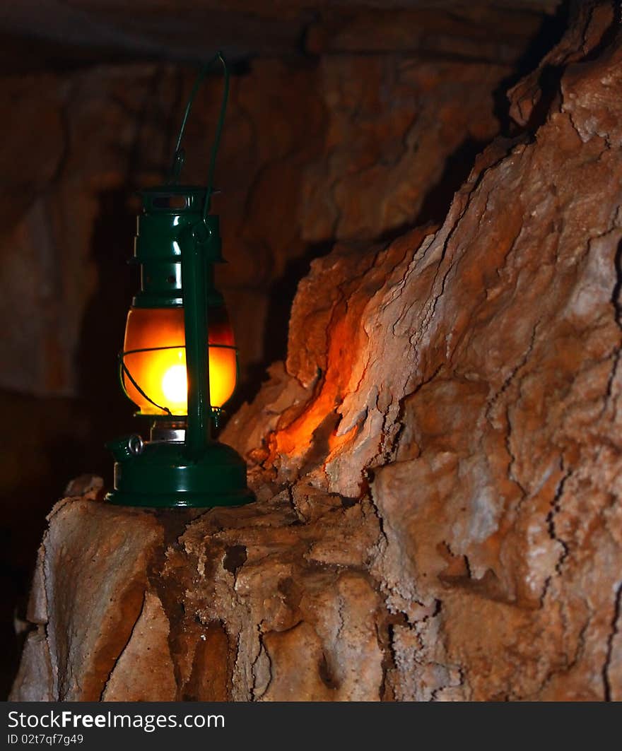 Oil lamp lighting the side of a red wall cave. Oil lamp lighting the side of a red wall cave.