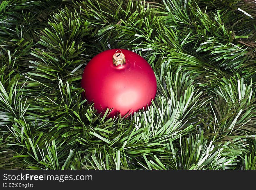 Red bomblet on green christmas chain background