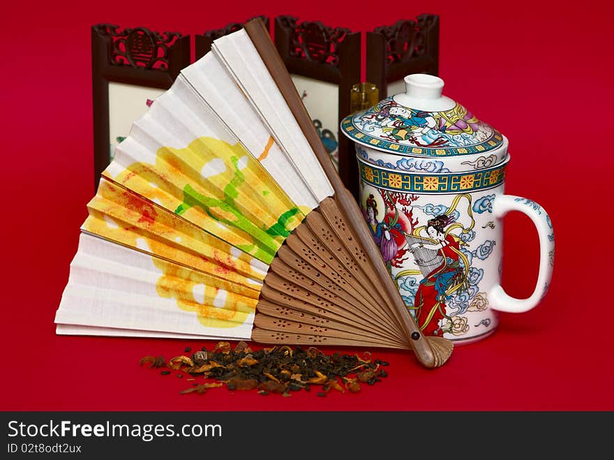 Fan and cup in asian style isolated on red background