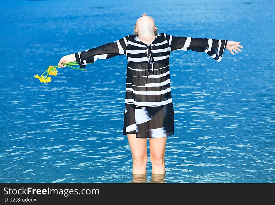 Beautiful woman with flowers in the sea. Beautiful woman with flowers in the sea