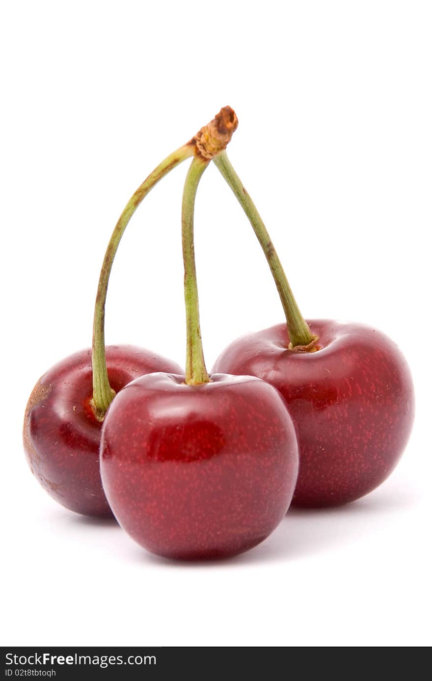 Three red cherries on a white background