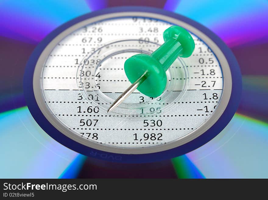 A compact disk putting on a data sheet, with a green drawing pin point to center, means data and analysis business concept. A compact disk putting on a data sheet, with a green drawing pin point to center, means data and analysis business concept.