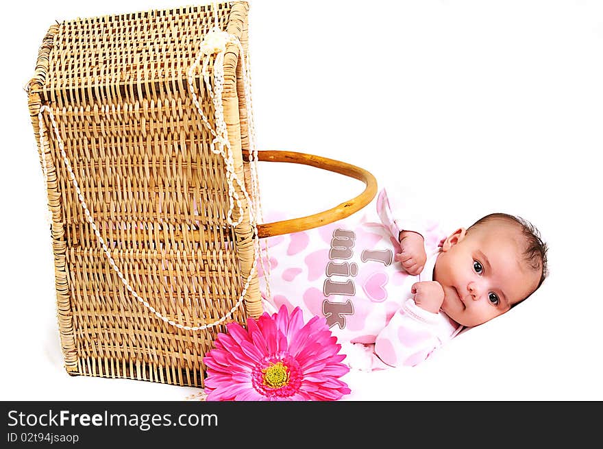 Newborn baby girl laying in a brown basket, white beads and big pink flower. Newborn baby girl laying in a brown basket, white beads and big pink flower