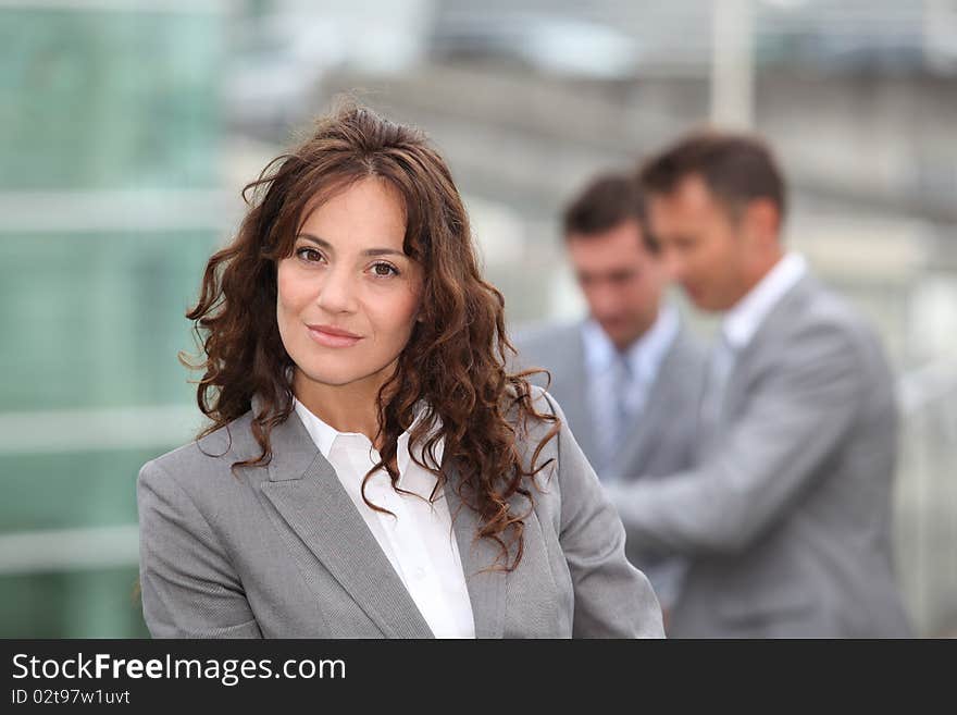 Portrait of businesswoman standing in front of businessemen. Portrait of businesswoman standing in front of businessemen