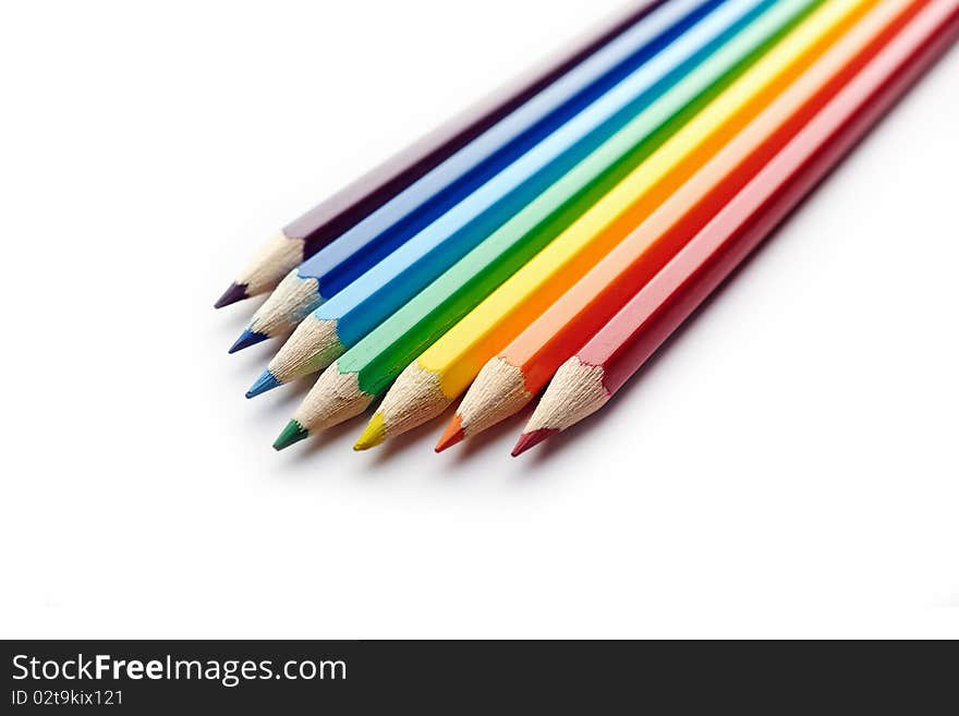 Colored pencils arranged in rainbow spectrum order isolated on white background