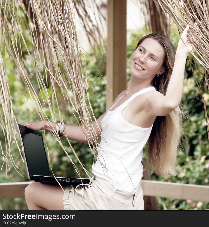 Beautiful young woman outdoors in the summer day.